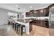 Modern kitchen features a granite island with stool seating and dark wood cabinets at 11712 Winterset Cove Dr, Riverview, FL 33579