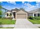 Charming single-story home with a well-manicured lawn and attached two-car garage at 1214 Florablu Dr, Seffner, FL 33584