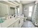 Bathroom featuring white vanity, quartz countertop, black hardware, and tiled bath with shower at 12432 81St Ct, Seminole, FL 33772
