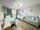 Bedroom with two twin beds, plaid sofa, nautical themed pillows, and light colored hardwood floors at 12432 81St Ct, Seminole, FL 33772