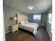 Cozy bedroom featuring a large upholstered headboard, wood floors, and stylish decor at 12432 81St Ct, Seminole, FL 33772