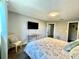 Bedroom featuring floral patterned bedspread, hardwood floors, closet, and a flat screen television at 12432 81St Ct, Seminole, FL 33772