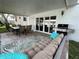 Relaxing covered patio featuring comfortable seating, a grill, and seamless indoor-outdoor living at 12432 81St Ct, Seminole, FL 33772