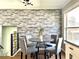 Dining area featuring a modern table with stylish chairs and a decorative brick wall at 12432 81St Ct, Seminole, FL 33772