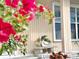 Home's charming front porch features quaint bench with a bird statue and colorful plants at 12432 81St Ct, Seminole, FL 33772