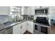 Updated kitchen featuring white cabinets, granite counters, stainless appliances, and mosaic backsplash at 12432 81St Ct, Seminole, FL 33772