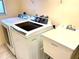 Functional laundry room equipped with a modern washer, dryer, and utility sink for convenience at 12432 81St Ct, Seminole, FL 33772
