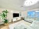 Open-concept living room with a large sectional sofa, flat screen tv, and light grey rug at 12432 81St Ct, Seminole, FL 33772