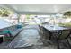Covered patio with comfortable seating, a dining area, and a relaxing hammock for outdoor enjoyment at 12432 81St Ct, Seminole, FL 33772