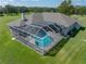 Aerial view of a house and the screened in backyard swimming pool and brick patio at 1292 Myers Rd, Brooksville, FL 34602