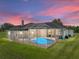 Aerial view of the house with a screened-in pool and deck at sunset at 1292 Myers Rd, Brooksville, FL 34602