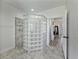 Bathroom featuring a glass block shower, gray tile and view into another room at 1292 Myers Rd, Brooksville, FL 34602
