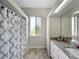 Bright bathroom features a shower with a patterned curtain, and granite countertop at 1292 Myers Rd, Brooksville, FL 34602