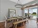 Inviting dining room featuring a rustic wood table, modern lighting, and views of the pool area at 1292 Myers Rd, Brooksville, FL 34602