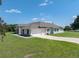 Exterior elevation showcasing the home's architecture, three car garage, and well-maintained landscaping at 1292 Myers Rd, Brooksville, FL 34602