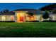 A single-story home at dusk, featuring an arched entryway, a lush lawn and manicured bushes at 1292 Myers Rd, Brooksville, FL 34602
