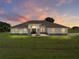 Beautiful single-story home with large front yard, brick accents, and a welcoming entrance against a colorful sunset sky at 1292 Myers Rd, Brooksville, FL 34602