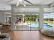 Open living space with views of the pool, outdoor kitchen, and dining area through large sliding glass doors at 1292 Myers Rd, Brooksville, FL 34602