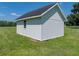 Side angle view of a well-maintained, white outbuilding situated on a large grassy plot at 1292 Myers Rd, Brooksville, FL 34602