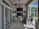 Outdoor kitchen with stainless grill, bar seating, and brick flooring under string lights with a screened in patio at 1292 Myers Rd, Brooksville, FL 34602