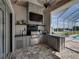 Outdoor kitchen featuring stone accent wall, bar top seating and stunning backyard views at 1292 Myers Rd, Brooksville, FL 34602