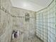 Shower featuring glass block wall, tile surround, corner shelves, and a shower bench at 1292 Myers Rd, Brooksville, FL 34602
