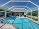 Backyard swimming pool inside a screened enclosure with brick patio, view of the house and yard at 1292 Myers Rd, Brooksville, FL 34602