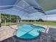 Swimming pool inside screened enclosure with views of fenced yard, and small building at 1292 Myers Rd, Brooksville, FL 34602