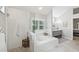 Elegant bathroom with a soaking tub, glass-enclosed shower, and dual vanity sinks at 13806 Sumac Pl, Tampa, FL 33625
