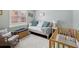 Bright bedroom with a white daybed, blue pillows, light walls, and a crib at 13806 Sumac Pl, Tampa, FL 33625