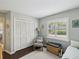 Cozy bedroom with a window, closet, chair, and light green walls at 13806 Sumac Pl, Tampa, FL 33625