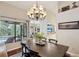 Bright dining room with wood floors, chandelier, and views of the pool and outdoor living space at 13806 Sumac Pl, Tampa, FL 33625
