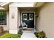 Welcoming front entrance with double doors, seasonal wreaths, fresh plants, and decorative lighting at 13806 Sumac Pl, Tampa, FL 33625