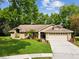Charming single-story home with a well-manicured lawn and an attached two-car garage at 13806 Sumac Pl, Tampa, FL 33625