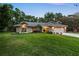 Well-maintained home with a lush green lawn, mature trees, and a two-car garage at 13806 Sumac Pl, Tampa, FL 33625