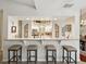 Kitchen bar with granite countertop and four bar stools, open to the main kitchen area at 13806 Sumac Pl, Tampa, FL 33625