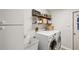 A laundry room featuring a utility sink, washer, dryer, and shelving at 13806 Sumac Pl, Tampa, FL 33625
