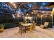 Outdoor screened patio with an outdoor dining set beneath string lights, perfect for relaxing and entertaining at 13806 Sumac Pl, Tampa, FL 33625