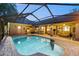 Exterior view of a pool surrounded by brick and an enclosed patio at 13806 Sumac Pl, Tampa, FL 33625