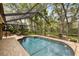 Screened pool area surrounded by mature trees and beautiful landscaping creates a private oasis at 13806 Sumac Pl, Tampa, FL 33625
