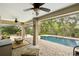 Relaxing screened-in patio area with ceiling fans, seating, and a sparkling swimming pool at 13806 Sumac Pl, Tampa, FL 33625