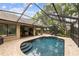 Backyard pool area surrounded by brick with seating and trees at 13806 Sumac Pl, Tampa, FL 33625