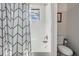 Bathroom features shower-tub combo with white tile and gray patterned curtain at 14507 Woodland Spur Dr, Lithia, FL 33547