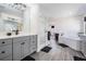 Well lit primary bathroom features a glass shower, gray cabinets, and wood-look flooring at 14507 Woodland Spur Dr, Lithia, FL 33547