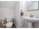 Powder room featuring a pedestal sink, toilet and accessories at 14507 Woodland Spur Dr, Lithia, FL 33547