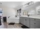 Bright bathroom with gray cabinets, a large mirror, soaking tub, and glass enclosed shower at 14507 Woodland Spur Dr, Lithia, FL 33547