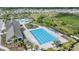 Resort style community pool with many lounge chairs, large lap pool, clubhouse, and palm tree landscaping at 14507 Woodland Spur Dr, Lithia, FL 33547