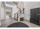 Bright foyer featuring a staircase, coat rack, and a decorative rug on wood-look flooring at 14507 Woodland Spur Dr, Lithia, FL 33547