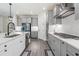 Modern kitchen features gray cabinets, stainless steel appliances, gas range, a large island with sink and bar seating at 14507 Woodland Spur Dr, Lithia, FL 33547