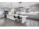 Modern kitchen features gray cabinets, gray wood flooring, stainless steel appliances and a large island with seating at 14507 Woodland Spur Dr, Lithia, FL 33547